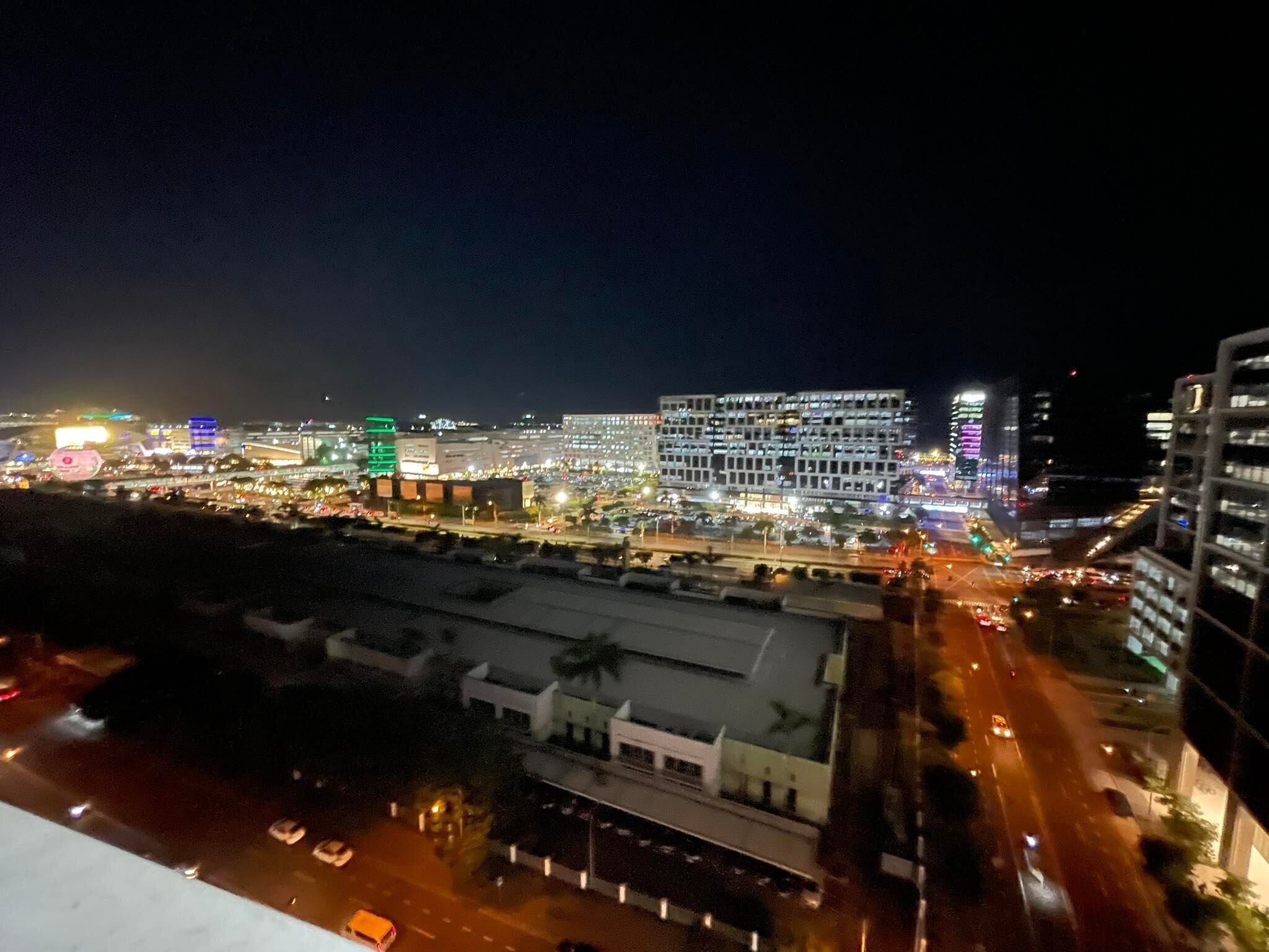 A nighttime cityscape with illuminated buildings and busy streets.