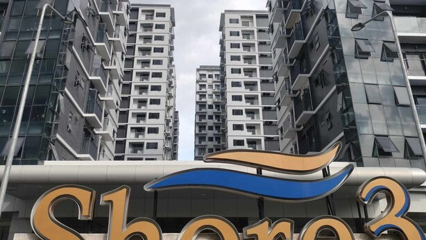 A modern high-rise building with a prominent 'Shore3' sign at the base.