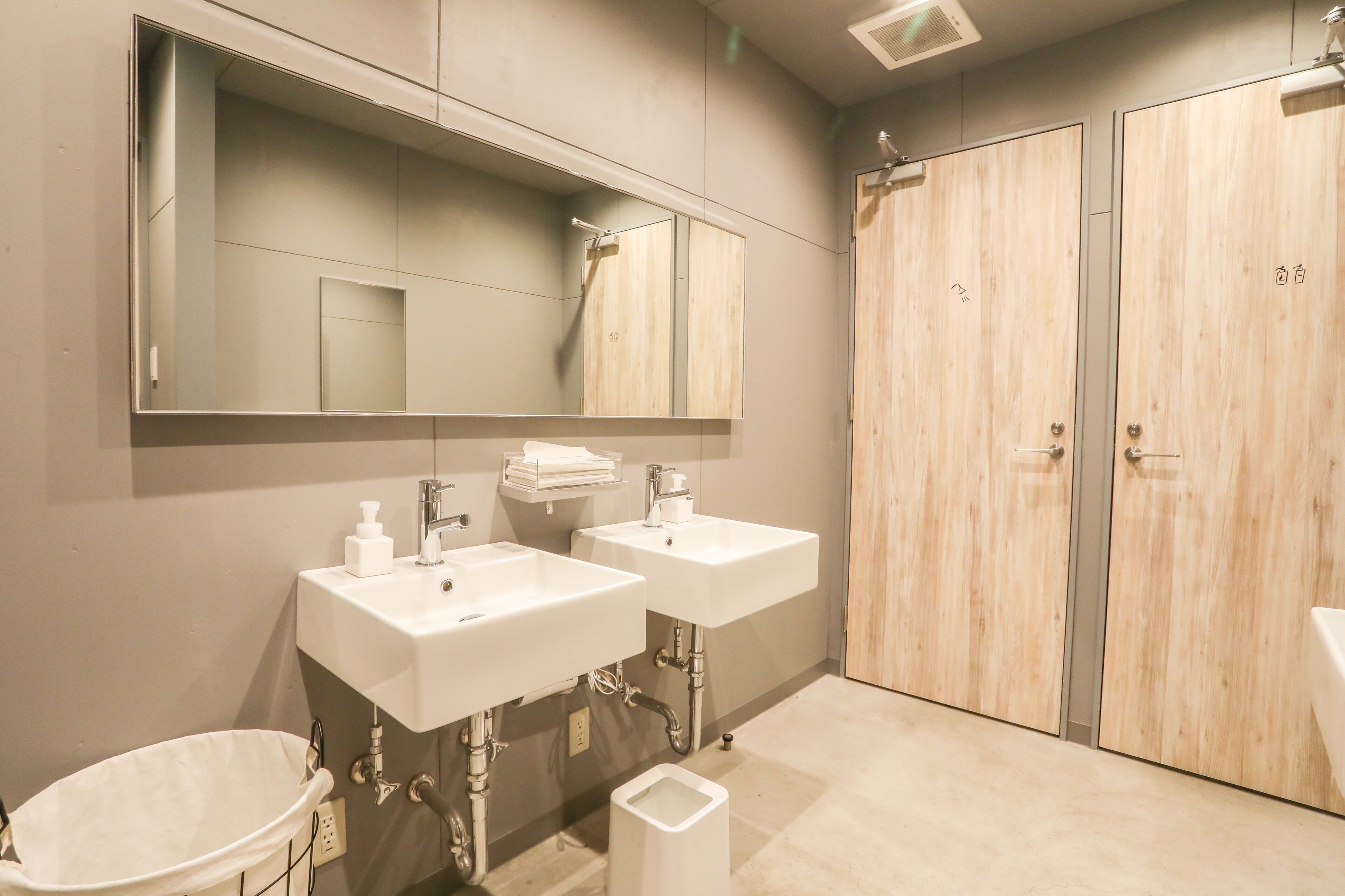 Une salle de bain moderne avec deux vasques, un grand miroir et des meubles en bois.