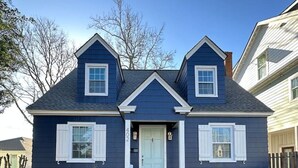 A two-story house with a front porch, a central door, and two windows on the upper floor. - The Breaker-2 Blks from Beach (Virginia Beach)
