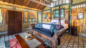 A traditional wooden room with a bed, sofa, and a small table. - BICKERTON ESTATE (Pecatu)