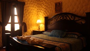 Une chambre avec un lit, une table de chevet, une lampe et une fenêtre avec des rideaux.