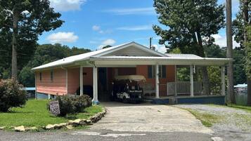 A house with a porch, a covered area, and a golf cart.