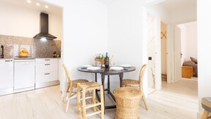 Une cuisine moderne avec des armoires blanches, un lave-vaisselle intégré et une hotte de couleur sombre.