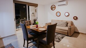 Ein modernes Wohnzimmer mit Essbereich, einer Couch und einem Couchtisch.