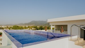 Ein Dachpool mit Infinity-Kante und freiem Blick auf die Berge im Hintergrund.