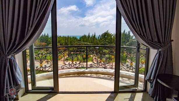 A balcony with a view of a garden and trees. - Con Son Blue Sea (Ho Chi Minh City)