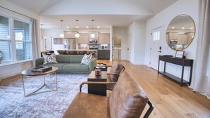 A spacious living area with a sofa, coffee table, and a dining table.