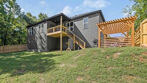 A two-story house with a covered patio and a wooden staircase leading to a deck.