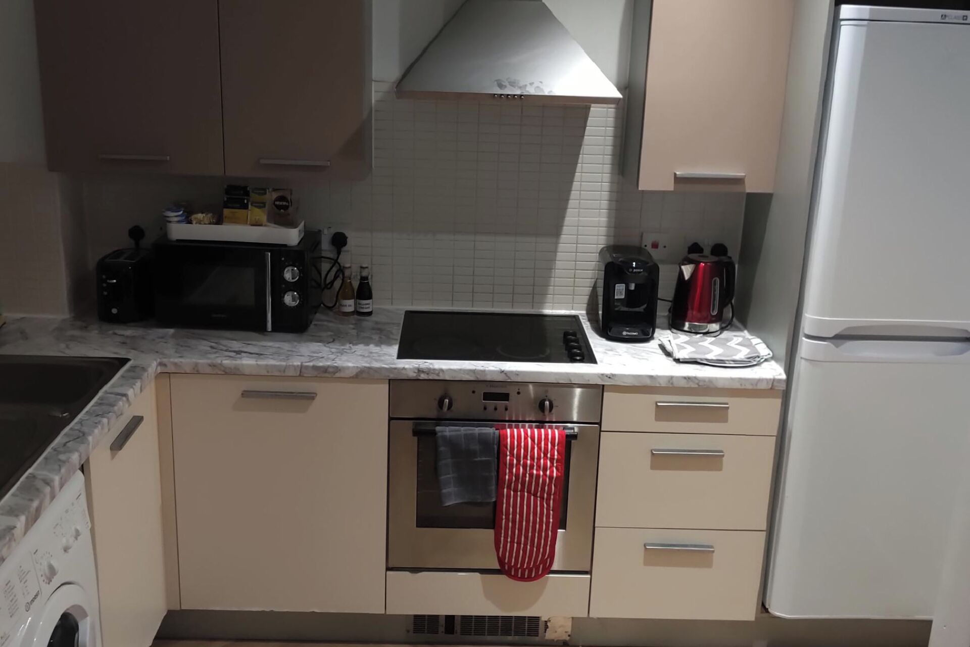 Une cuisine compacte équipée d’une cuisinière, d’un four à micro-ondes et d’une machine à café.