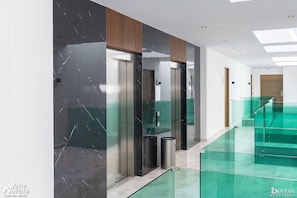 Experience the sleek, modern design of this upscale space, featuring a glass staircase and a clean, well-maintained atmosphere.