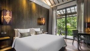 A modern hotel room with a large bed, wooden panel walls, and a balcony with a table and chairs. - Umayam Luxury Townhouse 7 by Alfred in Bali (Canggu)