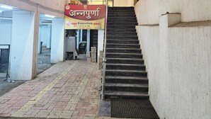 A staircase leading to a building with a sign reading "ANNAPURNA" and a banner with text in a local language. - Annapurna Executive (Tuljapur)