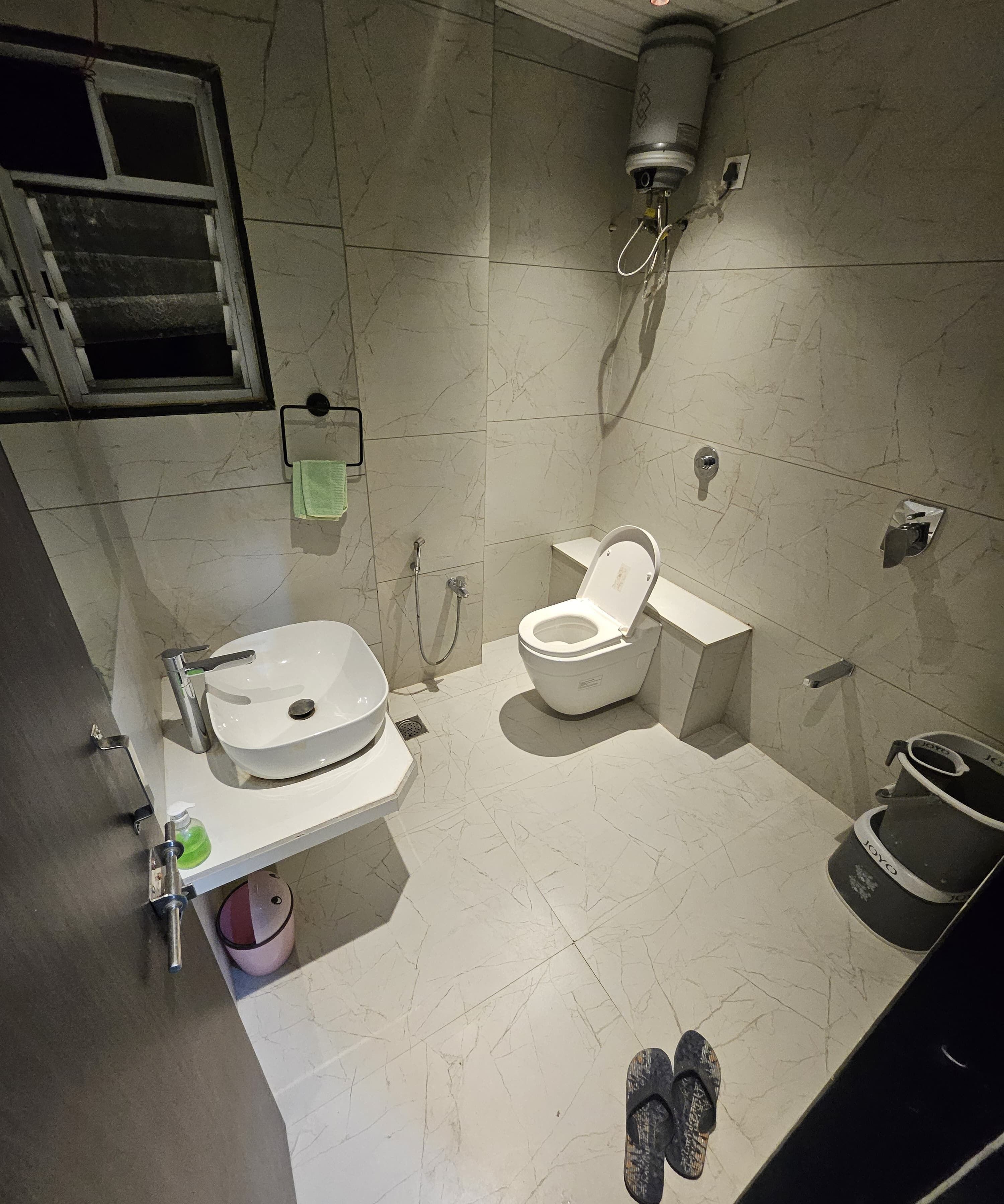 Une salle de bain comprenant des toilettes, un lavabo, une douche et un porte-serviettes.
