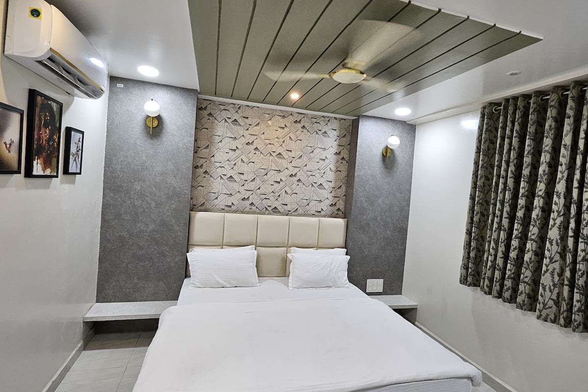 Un dormitorio moderno con una cama grande, una pared con diseño de piedra y un ventilador de techo.