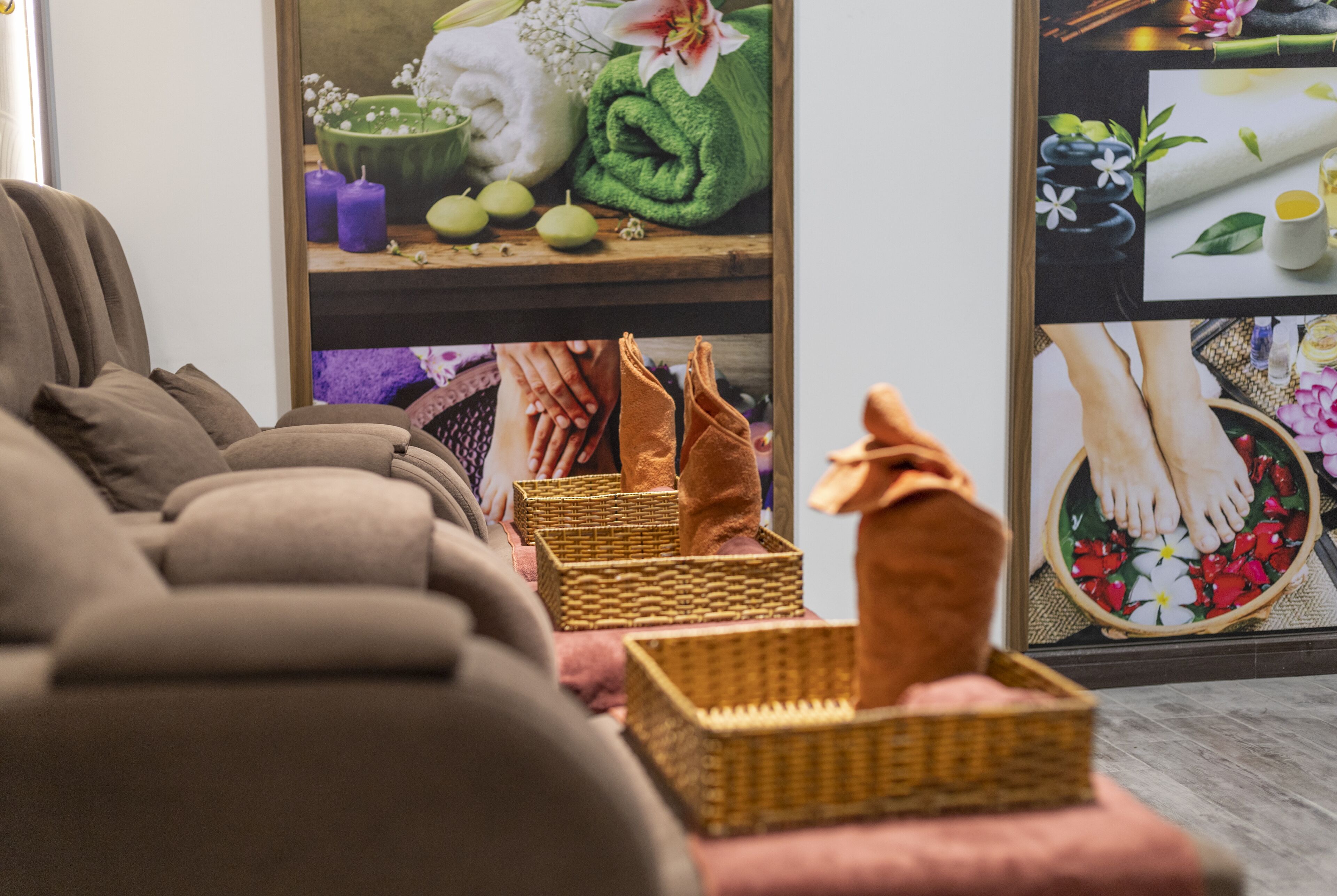 A spa room with a massage table, wicker baskets, and a poster of spa services.