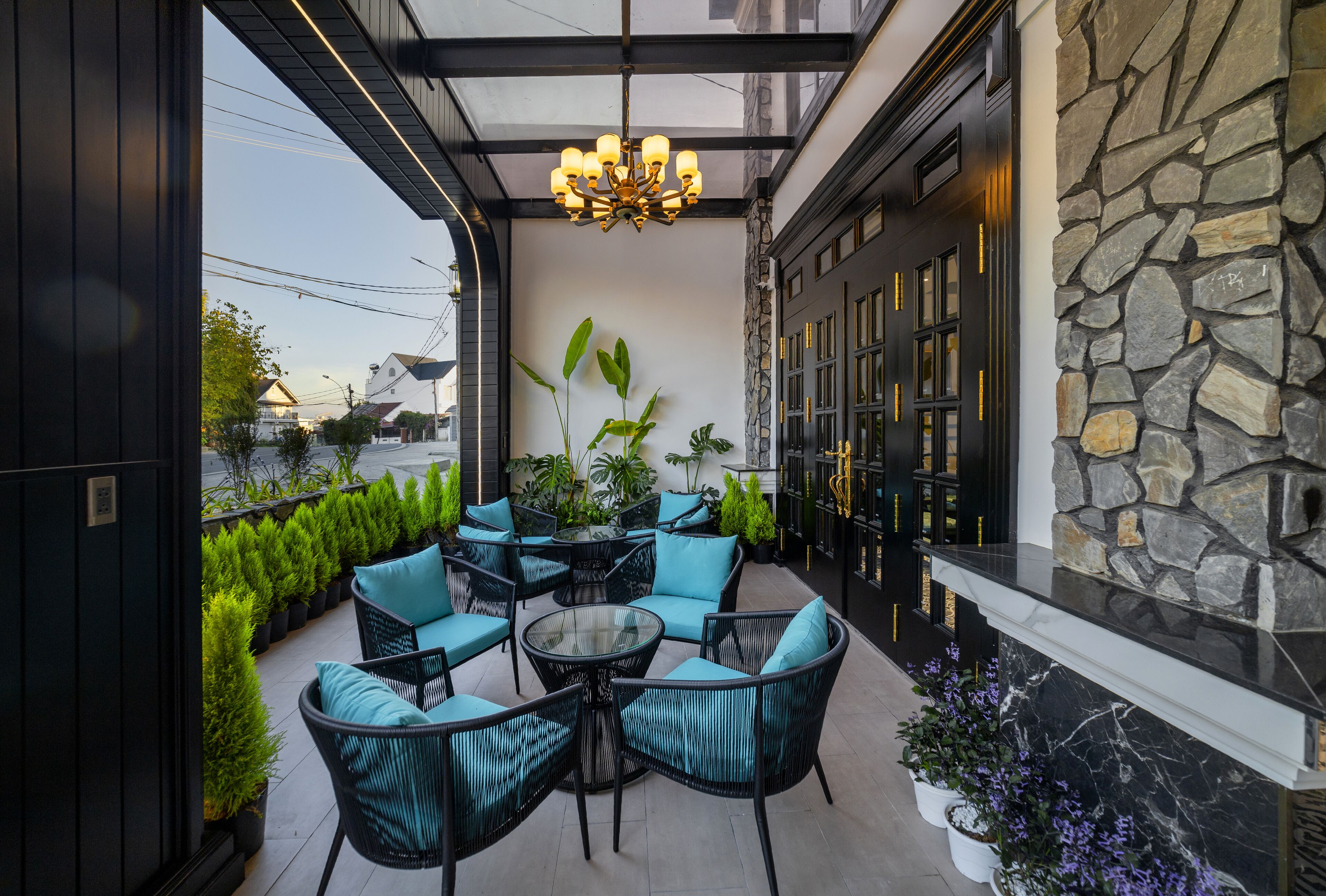 An outdoor patio with wicker furniture and potted plants.