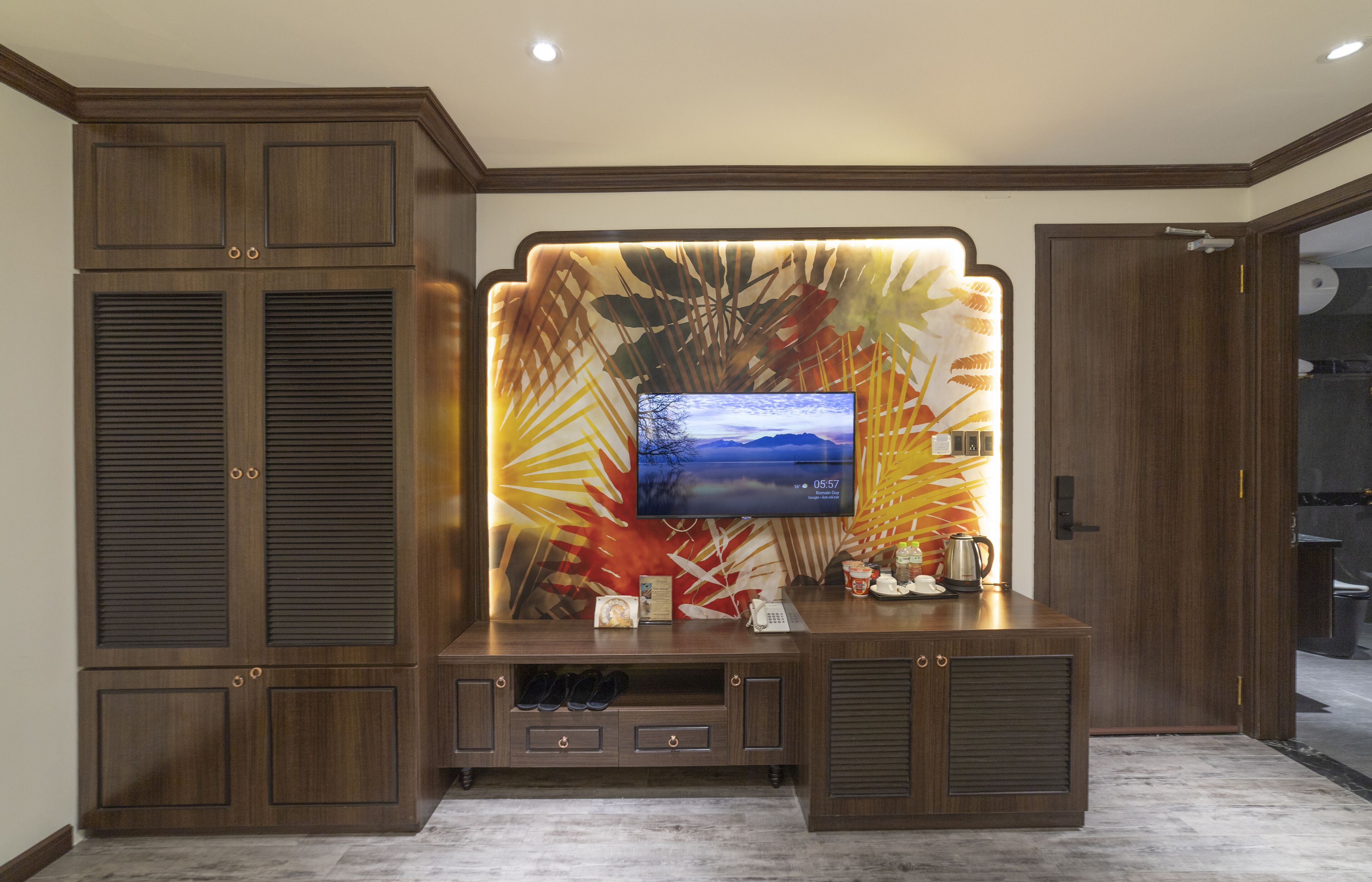 A modern entertainment unit with a flat-screen TV, built-in speakers, and a decorative wall panel.