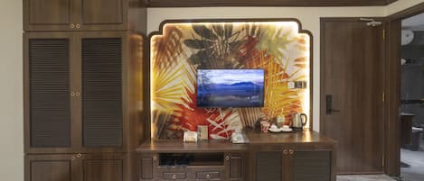 A modern entertainment unit with a flat-screen TV, built-in speakers, and a decorative wall panel.