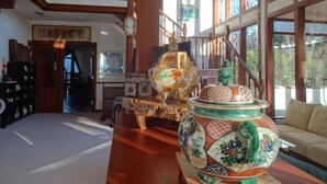 Uma sala de estar espaçosa com teto alto, escada de madeira e grandes janelas com vista para o exterior.