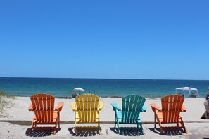 Four Adirondack chairs on a sandy beach with a clear view of the ocean. - Private Pool | Kayaks | Games | Las Olas Fun Modern Beachfront Luxury 30 Seconds to  Beach Sea La Vi (Fort Lauderdale)