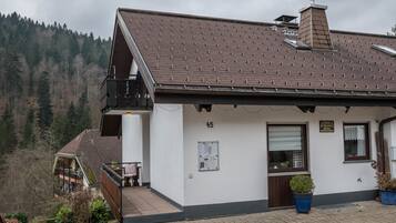 Een gebouw met een schuin dak, een balkon en een nummer '45'.