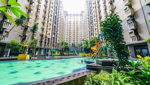 A residential building with a swimming pool, playground, and greenery. - OYO Life 93251 Apartement Gateway Cicadas By Alugada (Bandung)