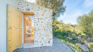 Un bâtiment en pierre avec une porte en bois et un petit porche.