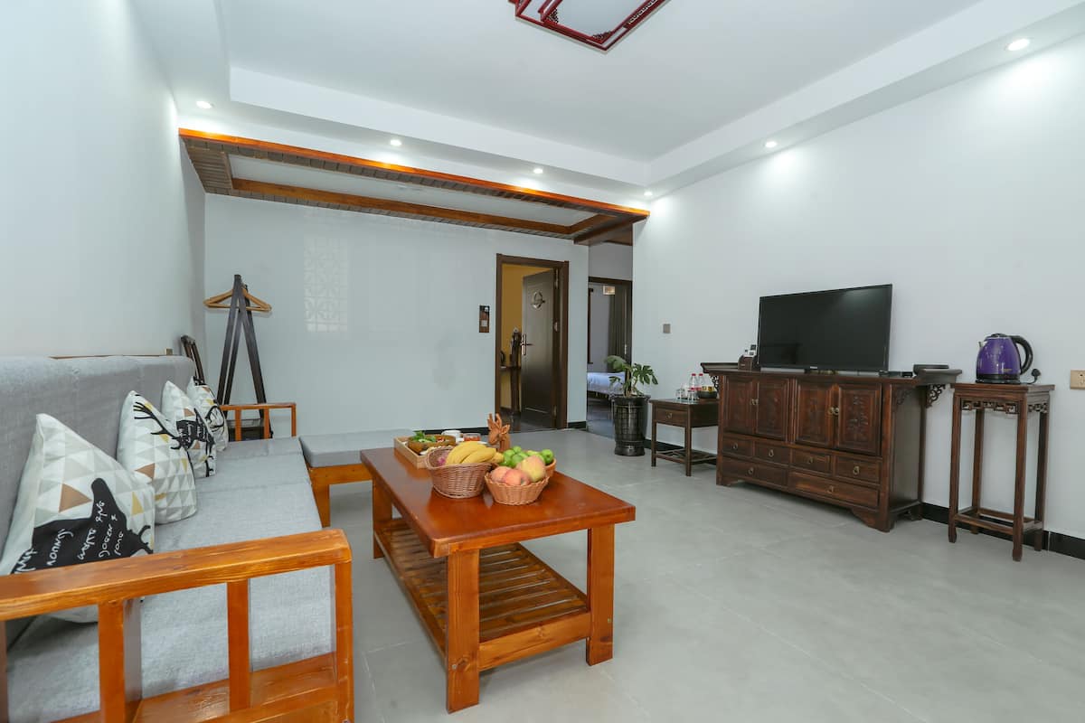A modern living room with a sofa, wooden coffee table, and a television.