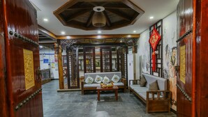 A traditional interior with a sofa, a table with fruit, and decorative elements. - mountainside (Zhangjiajie)