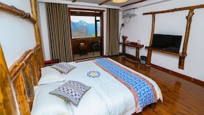 A bedroom with a wooden bed, a TV, a window with a mountain view, and a door leading to a balcony. - mountainside (Zhangjiajie)