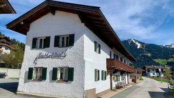 A white building with green shutters and a sign reading 'Feithenhause.'