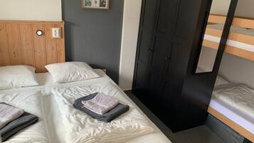 Ein Hotelzimmer mit Bett, Schrank, Spiegel und einem an der Wand hängenden Bild.