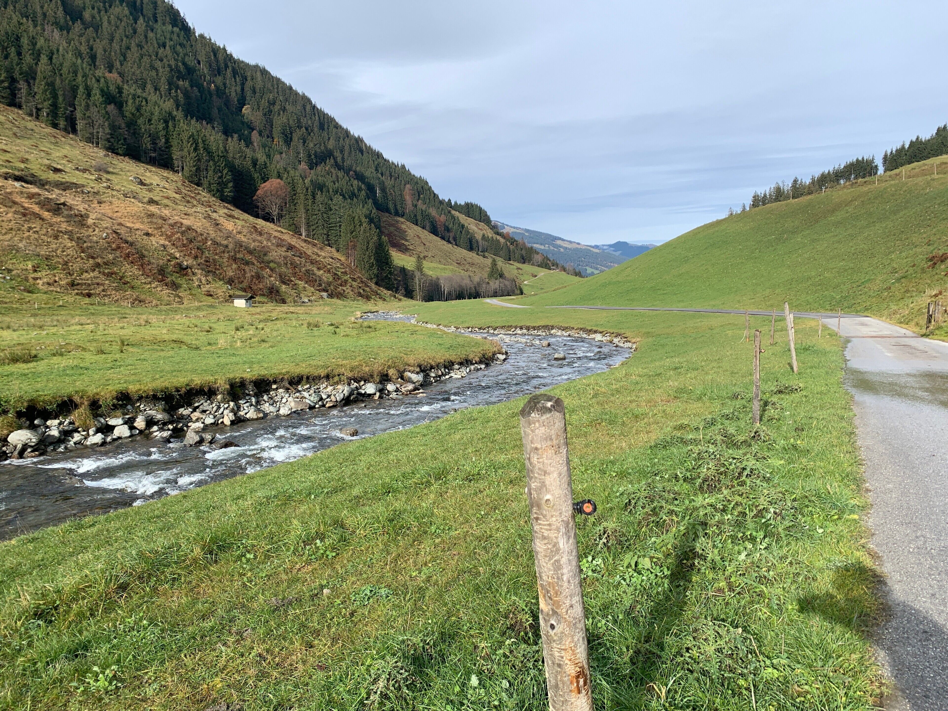 Ländliche Landschaft mit Fluss, Wiesen und einer Straße.