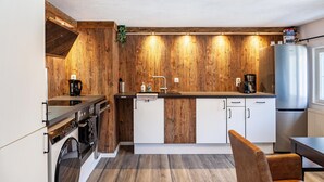 Een moderne keuken met houten details, roestvrijstalen apparatuur en een inbouwoven.