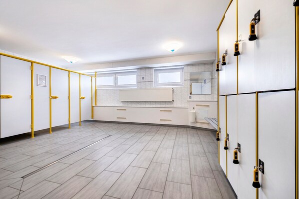 A hotel room with a large window, a bed, a desk, and a wardrobe. - Apartment 'Wellness Strandperle' with Garden, Private Balcony and Wi-Fi (Cuxhaven)