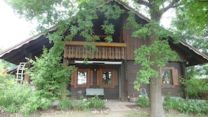 Une cabane en bois avec une véranda, un banc et une échelle.