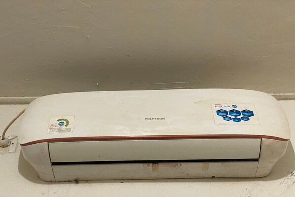 A white air conditioning unit with a red trim and a control panel on the right side.