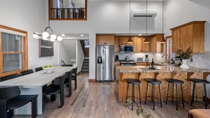 Una cocina moderna con una isla central, electrodomésticos de acero inoxidable y armarios de madera.