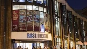 Un théâtre à la façade incurvée et aux grandes fenêtres en verre, avec une enseigne bien visible indiquant qu'il s'agit du Rose Theatre.