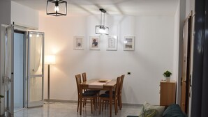 Un salon moderne comprenant un coin repas, un canapé, une table et un luminaire suspendu au plafond.