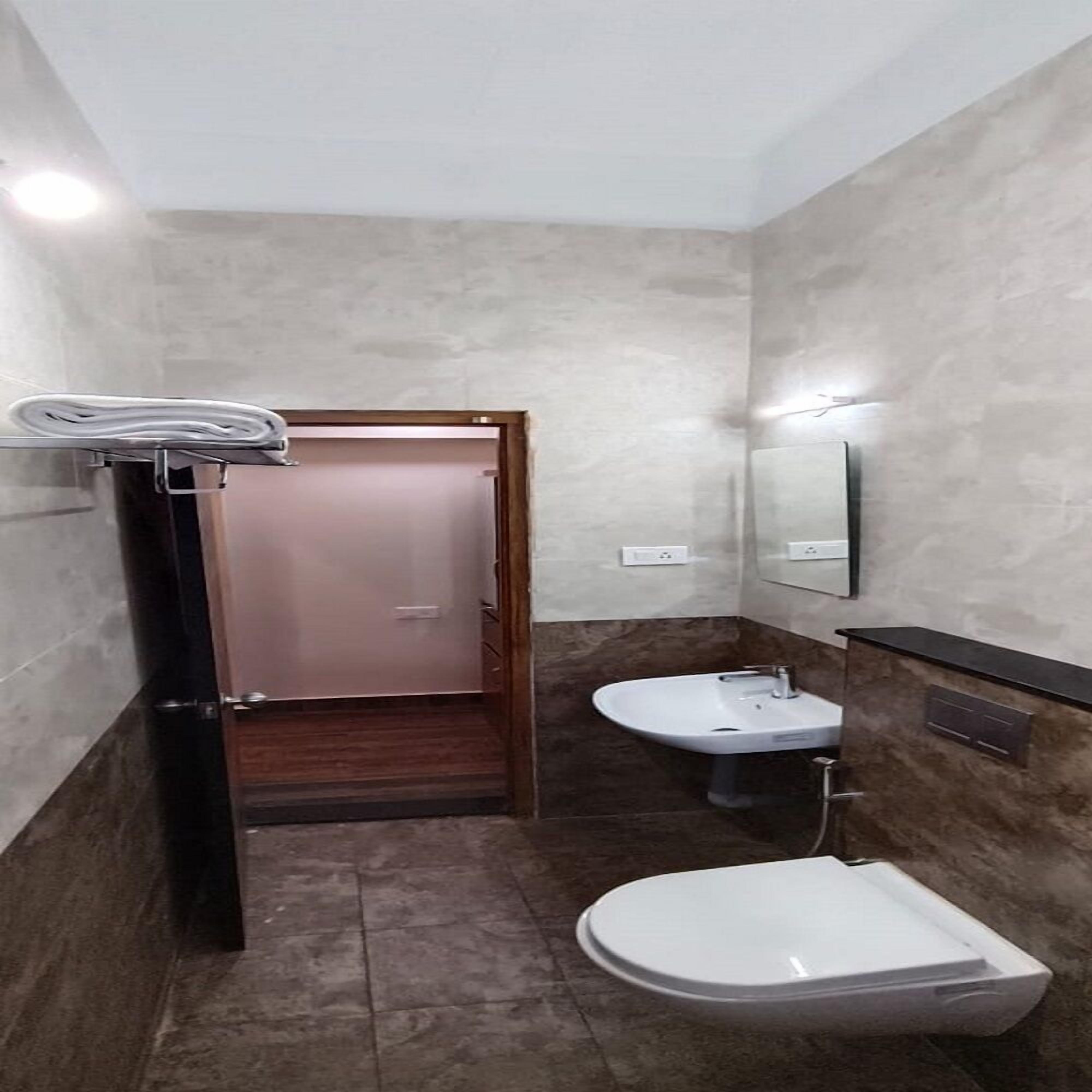 A bathroom with a toilet, sink, and mirror.