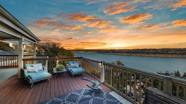 A deck with outdoor furniture, a view of a river, and a sunset. - The Ascent - Waterfront Home w Priv Dock & Pool (Point Venture)