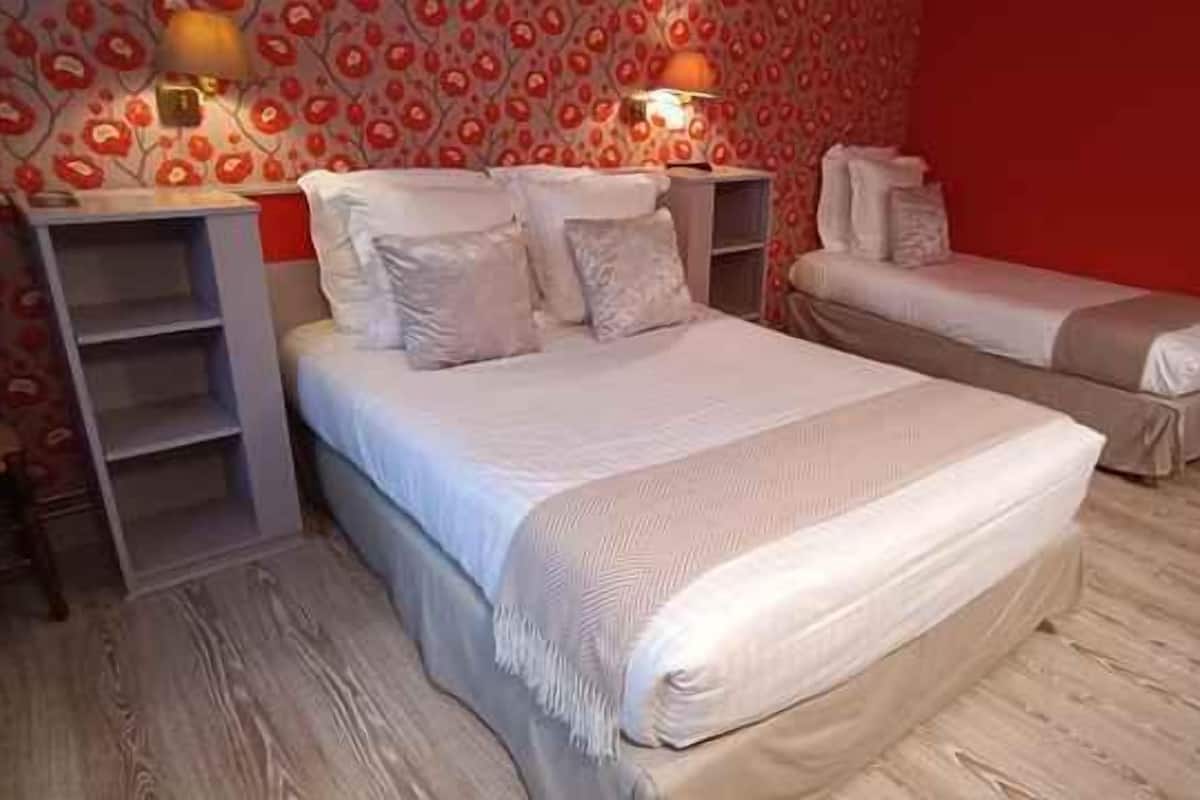 Une chambre à coucher avec un lit, des tables de chevet, une chaise et une armoire.