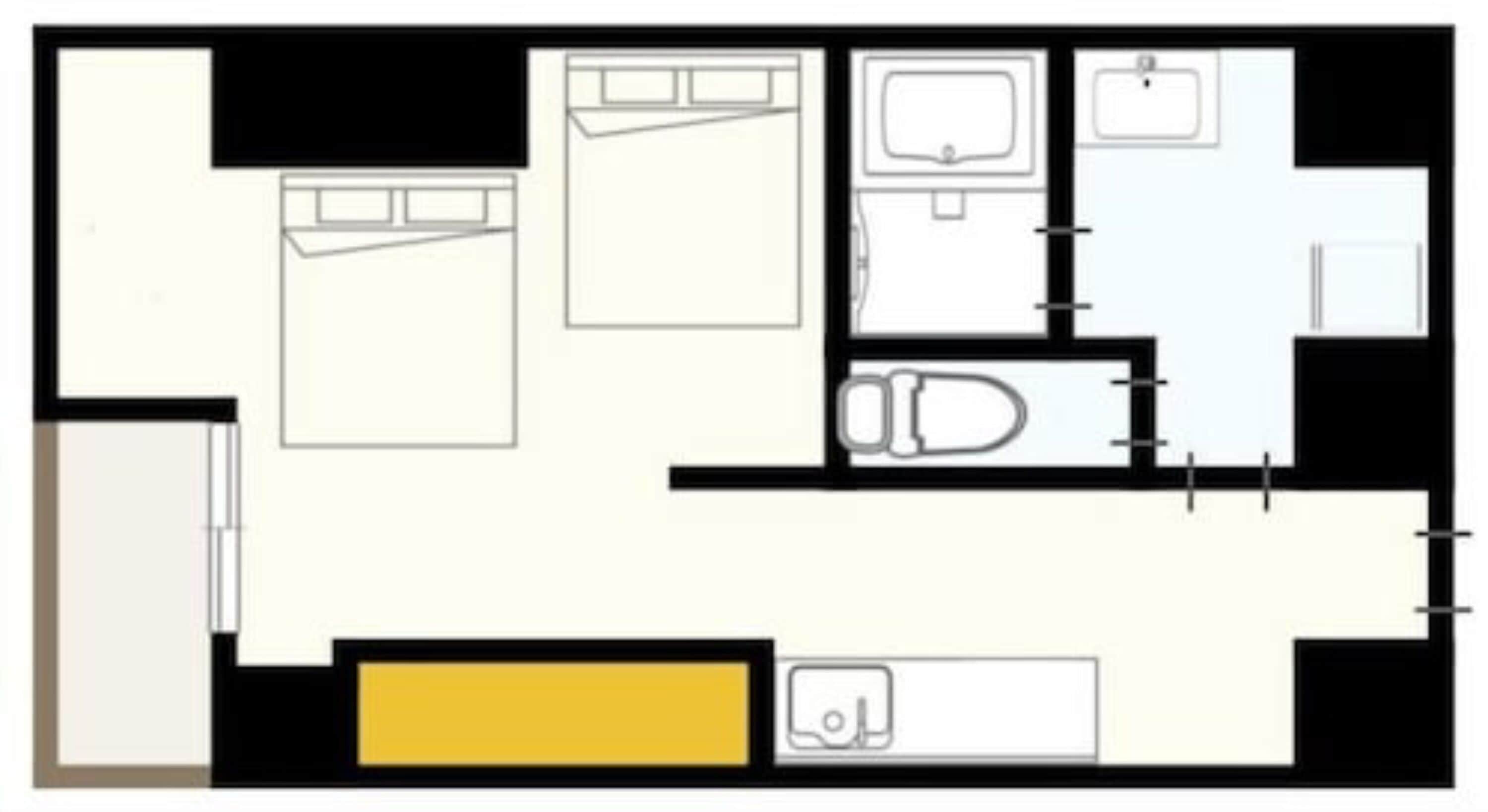 A floor plan of a hotel room with a bed, a bathroom, a kitchenette, and a small seating area.