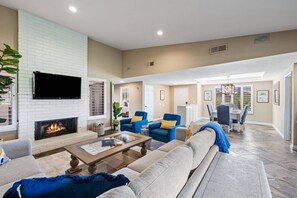 A spacious living room with a fireplace, comfortable seating, and a dining area. - Chaparral CC, Dual Main Bedrooms, Steps to Pool, Mountain/Golf Views (Palm Desert)