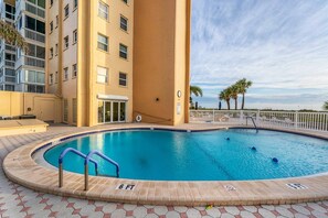 A swimming pool with a 6 FT depth marker, surrounded by a tiled deck and a building with multiple floors. - Gulf, Beach, Pool View Balcony on Venice Beach (Venice)