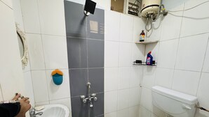 A bathroom with a white sink, a shower, and a toilet.