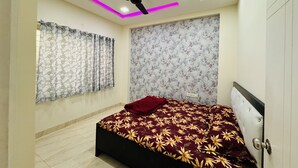 A bedroom with a bed, ceiling fan, and floral wallpaper.