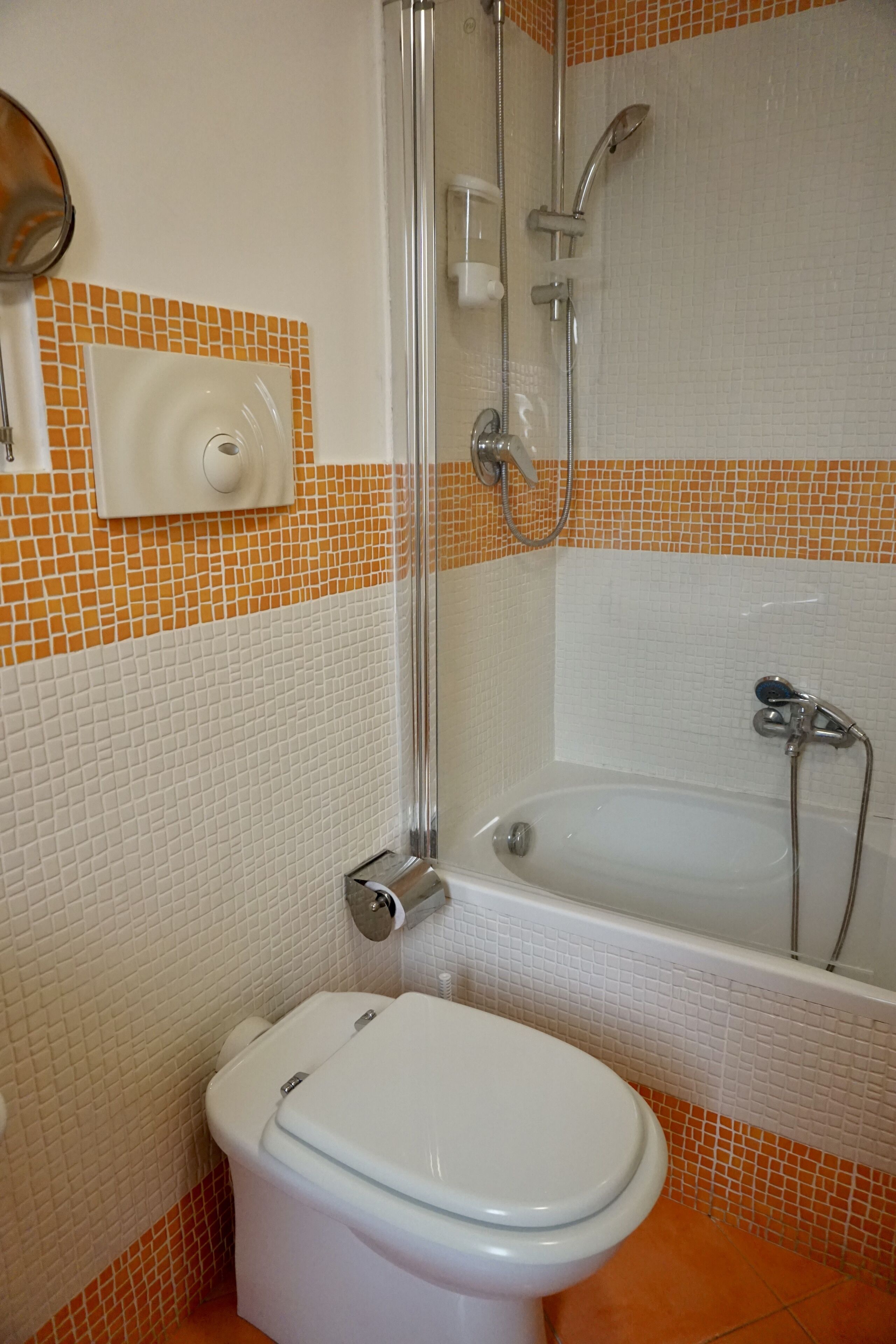 Une salle de bain équipée de toilettes, d’une douche et d’une baignoire.